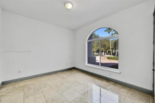 spare room featuring baseboards