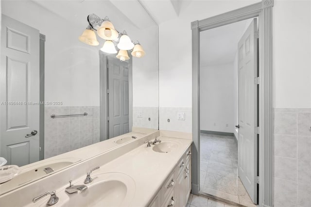 full bath with double vanity, a sink, and tile walls