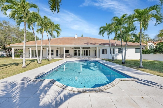 outdoor pool featuring french doors, a patio area, a yard, and ceiling fan