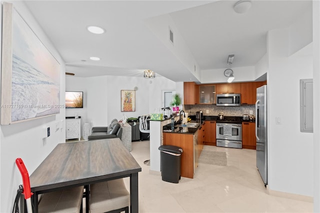 kitchen with stainless steel appliances, tasteful backsplash, sink, kitchen peninsula, and a breakfast bar area