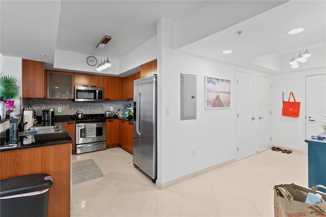 kitchen with decorative light fixtures, stainless steel appliances, tasteful backsplash, sink, and electric panel