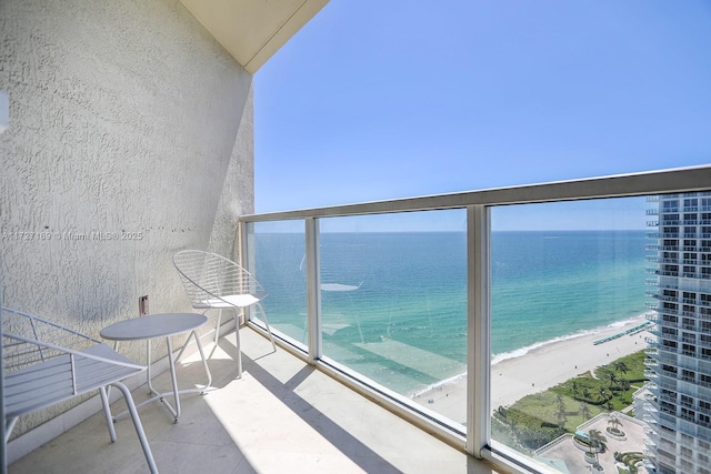 balcony featuring a water view and a beach view