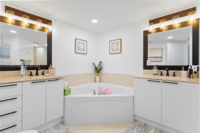 bathroom with a bathing tub, tile patterned floors, and vanity