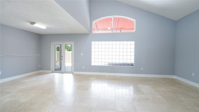 empty room featuring a textured ceiling and french doors