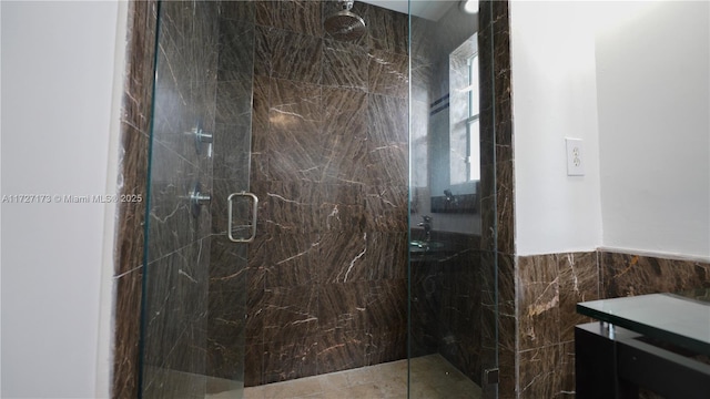 bathroom with a shower with shower door and tile walls