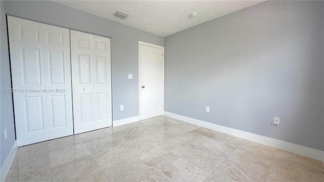 unfurnished bedroom with a closet and a textured ceiling