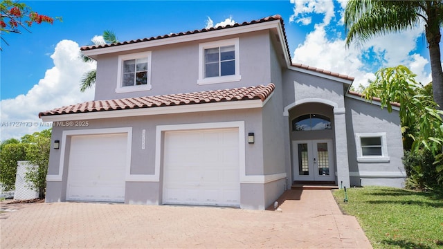 mediterranean / spanish-style home with a garage and french doors