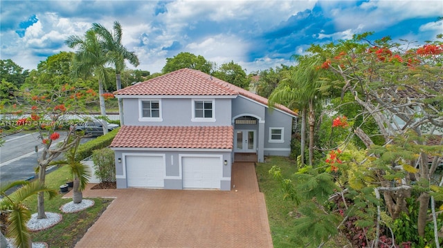 mediterranean / spanish home with a garage and french doors