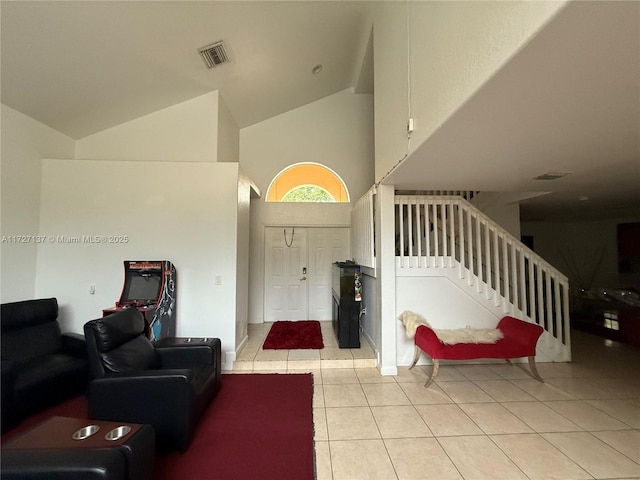 tiled foyer featuring high vaulted ceiling