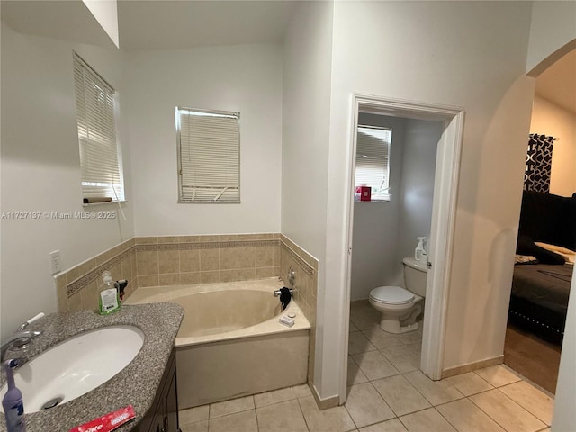 bathroom with toilet, vaulted ceiling, tile patterned floors, a tub to relax in, and sink