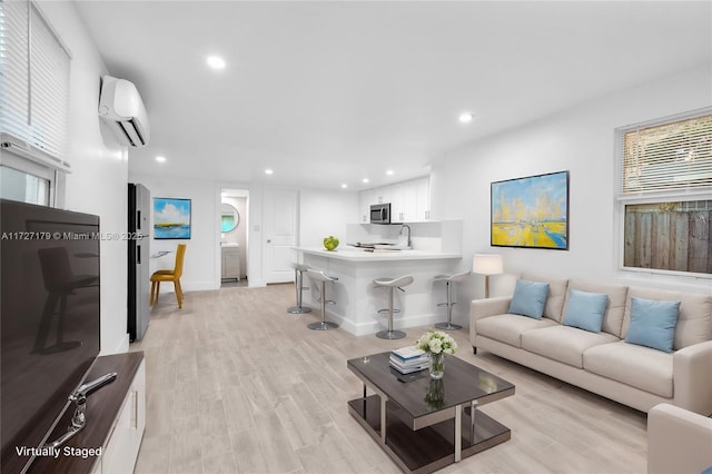 living room with light wood-type flooring and an AC wall unit