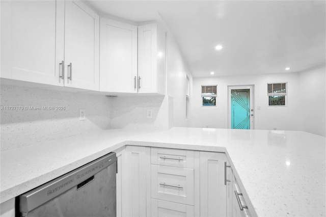 kitchen featuring light stone countertops, backsplash, white cabinets, and dishwasher