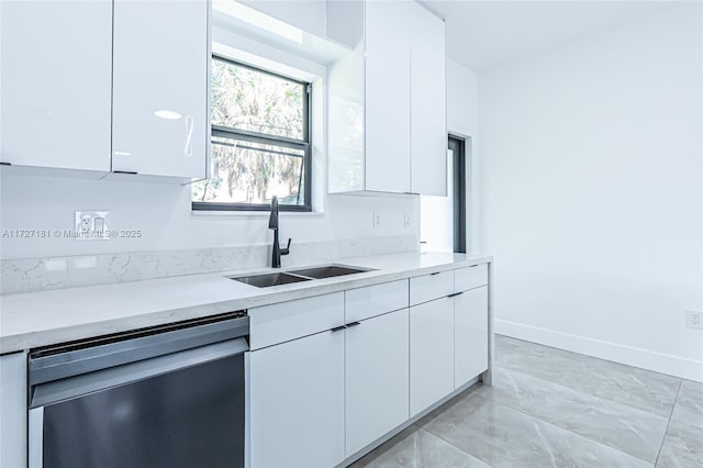 kitchen with white cabinetry, sink, light stone counters, and dishwashing machine