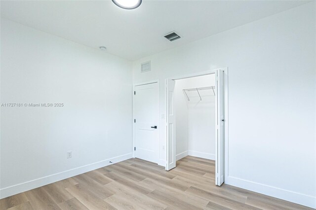 unfurnished bedroom featuring light wood-type flooring and a closet