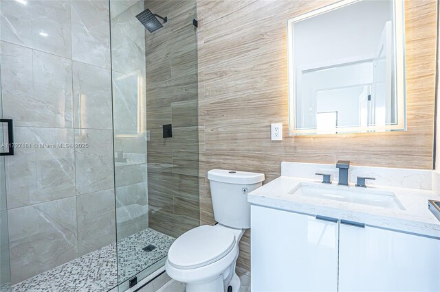 bathroom with toilet, tile walls, an enclosed shower, and vanity