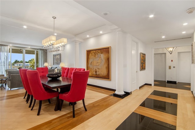 dining area with elevator, a notable chandelier, and light hardwood / wood-style flooring