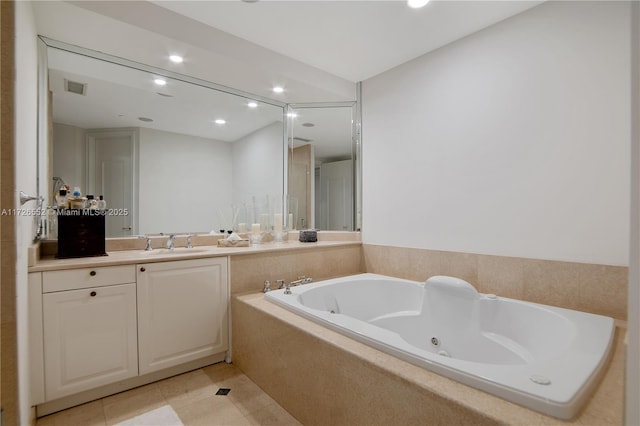 bathroom featuring vanity, tile patterned floors, and tiled tub