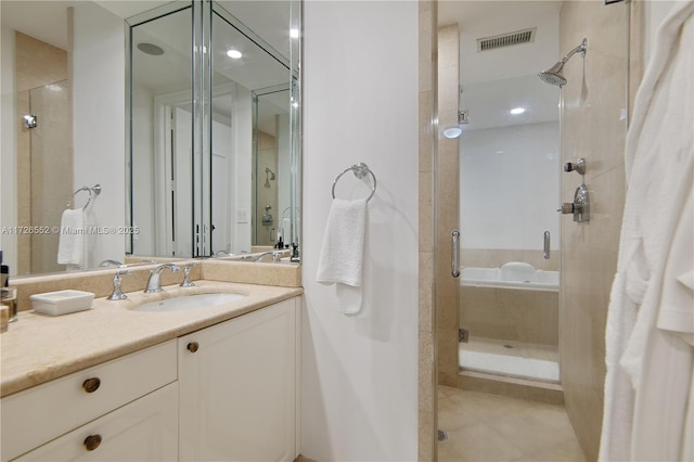 bathroom with a shower with door, tile patterned floors, and vanity