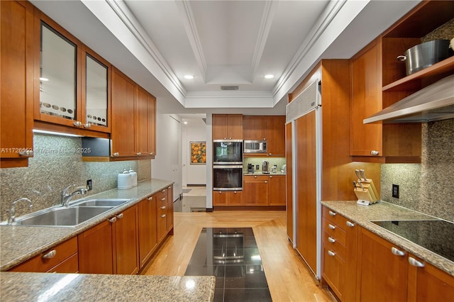 kitchen with black appliances, decorative backsplash, and a tray ceiling