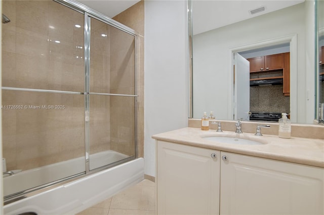 bathroom with combined bath / shower with glass door, tile patterned floors, backsplash, and vanity