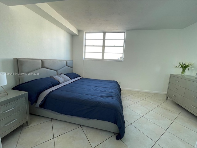 bedroom with baseboards and light tile patterned flooring