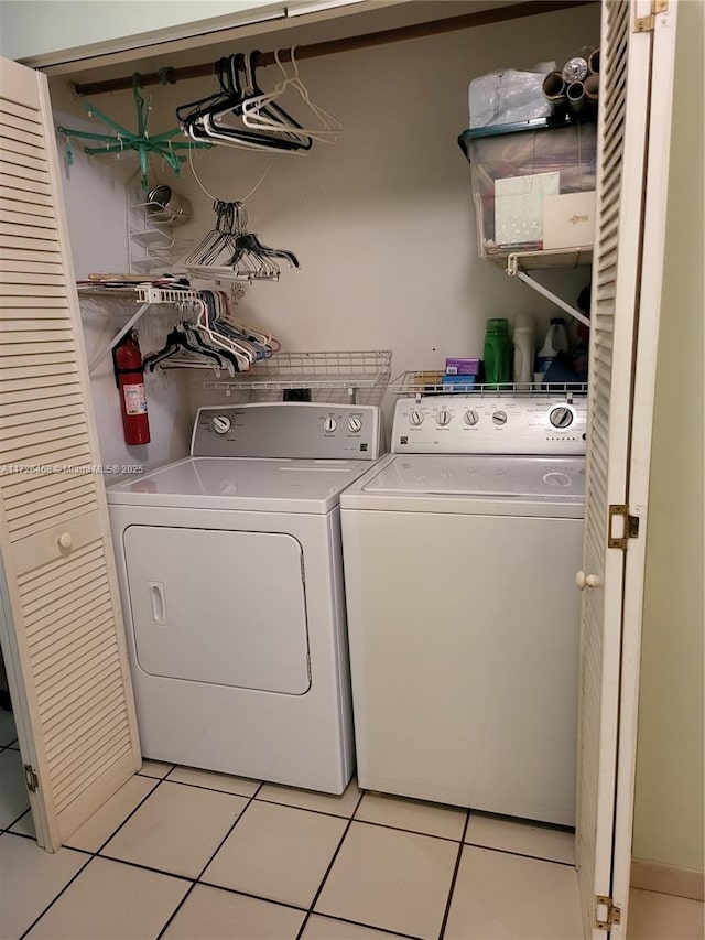 laundry area with separate washer and dryer and light tile patterned floors