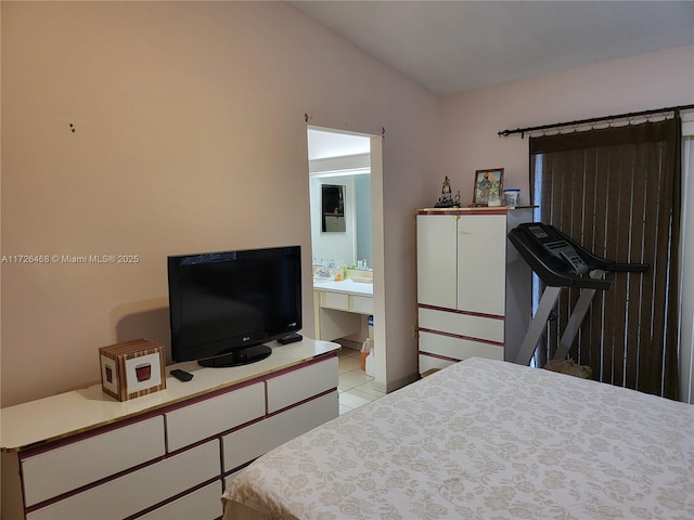 bedroom featuring light tile patterned floors, ensuite bath, and vaulted ceiling