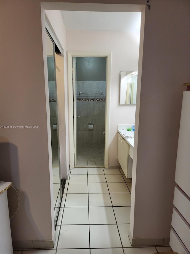 bathroom with toilet, vanity, and tile patterned flooring