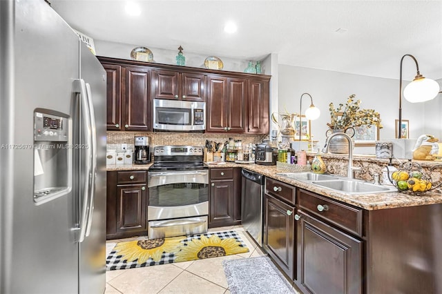 kitchen featuring light tile patterned floors, appliances with stainless steel finishes, tasteful backsplash, dark brown cabinets, and sink