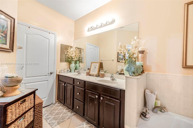 bathroom featuring a tub, a textured ceiling, tile patterned floors, and vanity