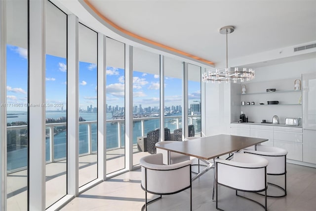 100 S Pointe Dr Unit 3203, Miami Beach, FL 33139 - dining area featuring a wall of windows, a view of skyline, a chandelier, a water view, and built in shelves