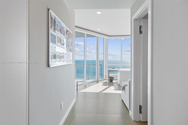 100 S Pointe Dr Unit 3203, Miami Beach, FL 33139 - corridor featuring a water view, baseboards, tile patterned floors, and floor to ceiling windows