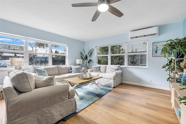 living room featuring ceiling fan, a wall mounted air conditioner, and light hardwood / wood-style floors