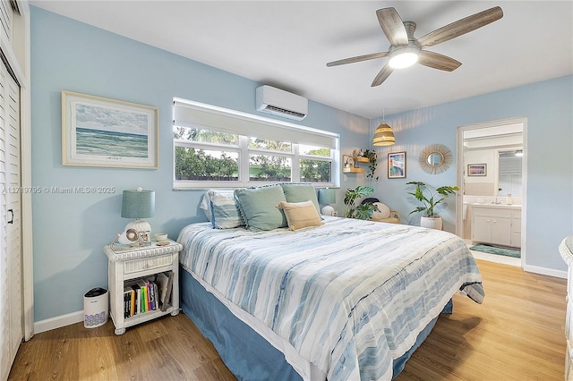 3209 Colony Club Rd Unit 1-W, Pompano Beach, FL 33062 - bedroom with an AC wall unit, light wood-type flooring, baseboards, and ensuite bathroom