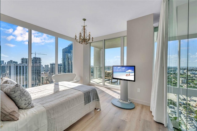 bedroom with multiple windows, wood-type flooring, and a notable chandelier