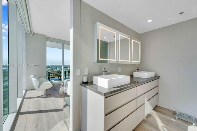 bathroom with expansive windows, vanity, and hardwood / wood-style flooring