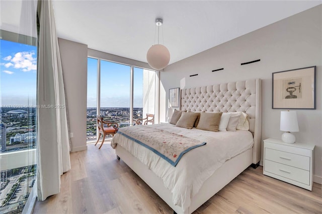 bedroom with access to exterior and light wood-type flooring