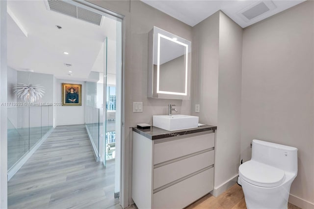 bathroom featuring hardwood / wood-style floors, toilet, and vanity