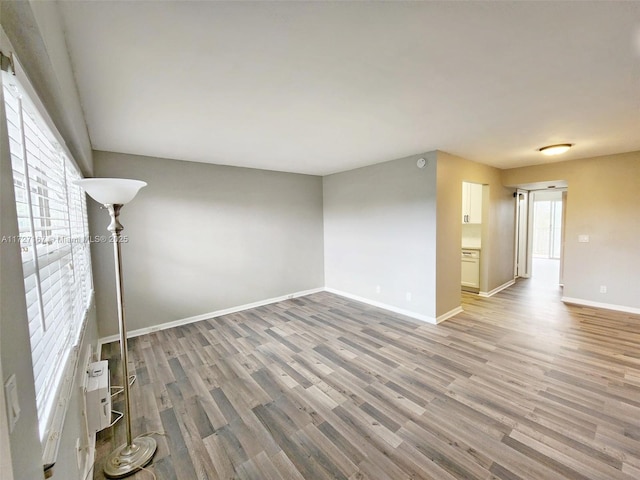 unfurnished living room featuring light wood-style flooring and baseboards