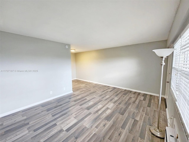 spare room with wood finished floors and baseboards