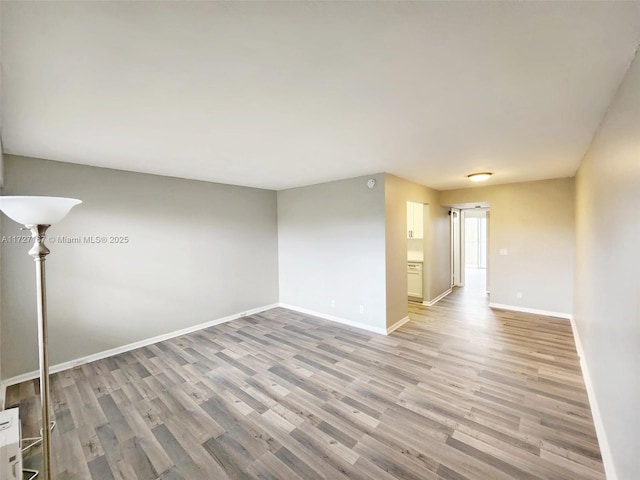 spare room with light wood finished floors and baseboards