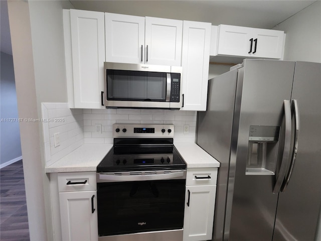 kitchen featuring tasteful backsplash, appliances with stainless steel finishes, white cabinetry, and hardwood / wood-style flooring