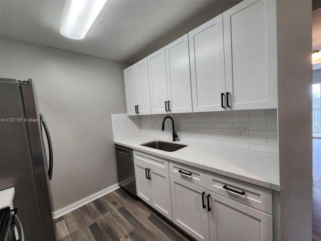 kitchen featuring decorative backsplash, dark wood-style flooring, stainless steel appliances, white cabinetry, and a sink