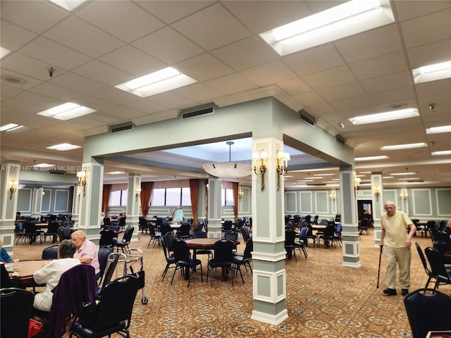 gym featuring visible vents, decorative columns, and a drop ceiling