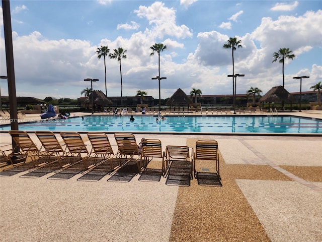 community pool featuring a water slide and a patio