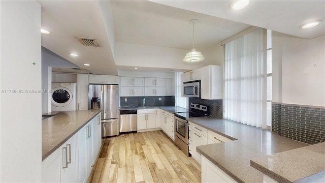 kitchen with white cabinetry, appliances with stainless steel finishes, decorative backsplash, light wood-type flooring, and hanging light fixtures