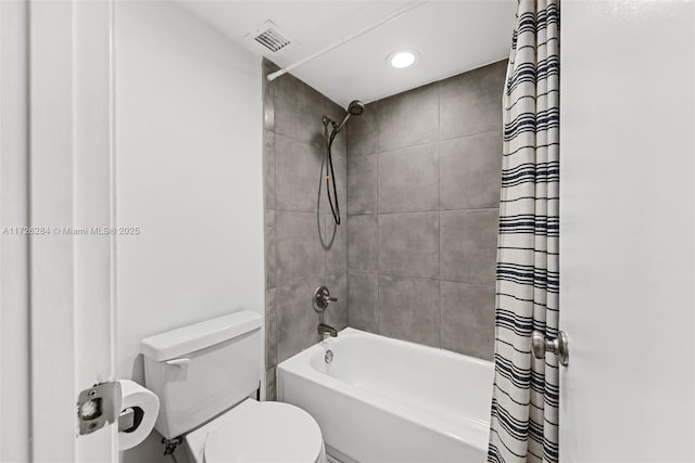 full bathroom featuring shower / bath combination with curtain, toilet, and visible vents