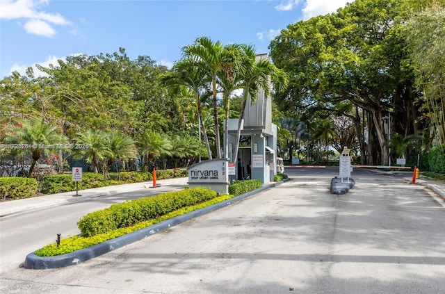 view of road featuring a gated entry and curbs