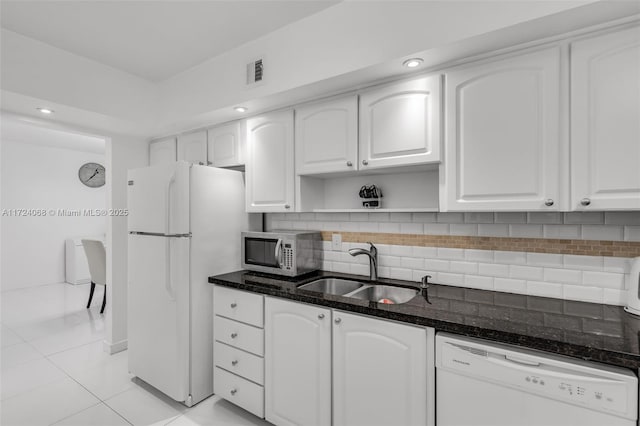 kitchen featuring white cabinets, dark stone counters, sink, and white appliances