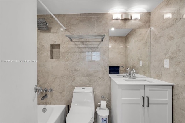 full bathroom with tile walls, toilet, vanity, and tiled shower / bath combo